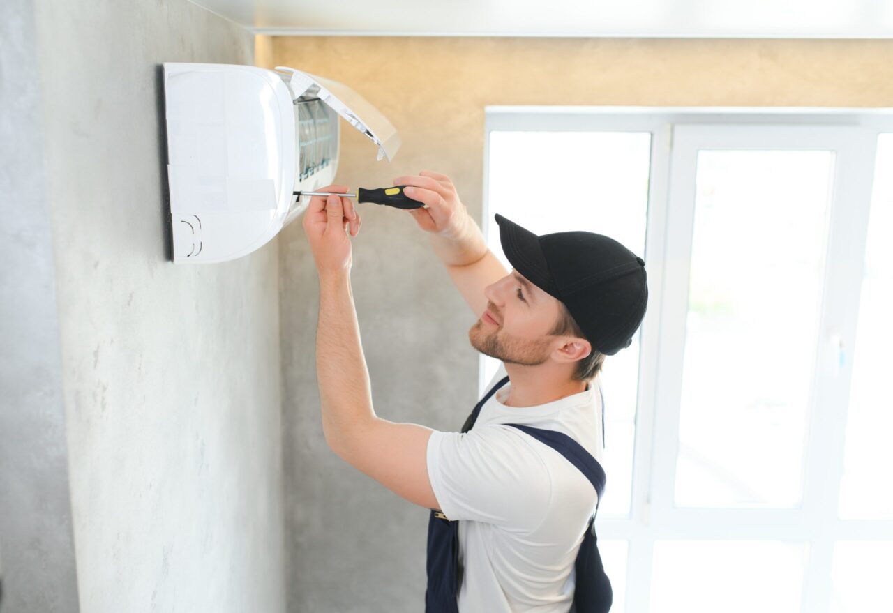 happy male technician repairing air conditioner 2023 11 27 05 26 38 utc scaled e1709696695267